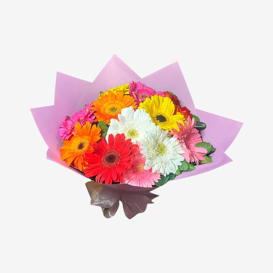 Ramo de 12 gerberas en distintos colores con papel lila y moño lila