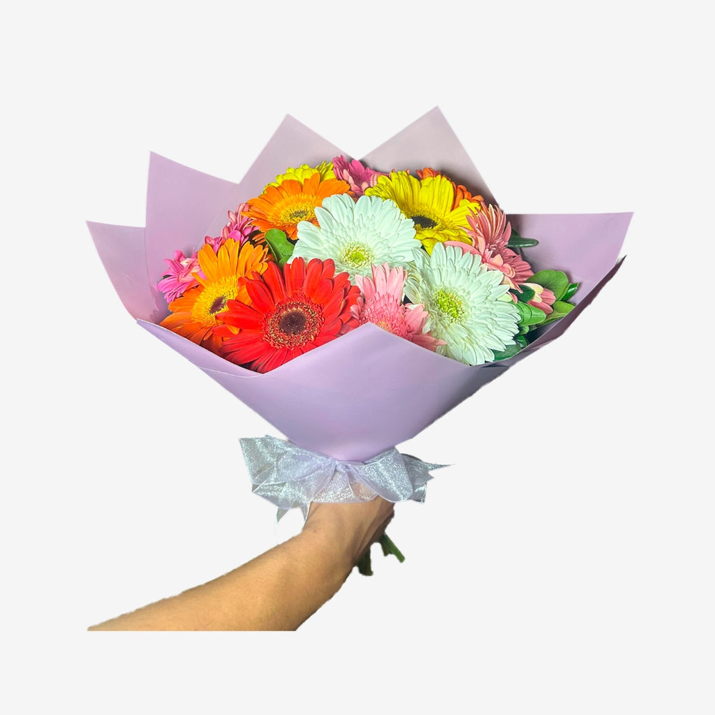 Ramo de 12 gerberas en distintos colores con papel morado y moño lila
