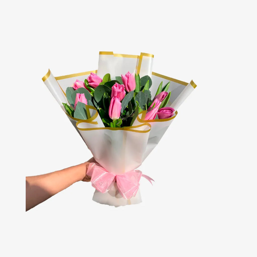 Ramo de 10 tulipanes con follaje envueltos en papel coreano blanco.
