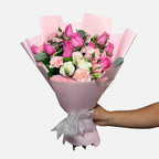 Ramo de 12 rosas rosas, clavel rosa, mini rose rosa y follaje. Envuelto en papel coreano rosa.