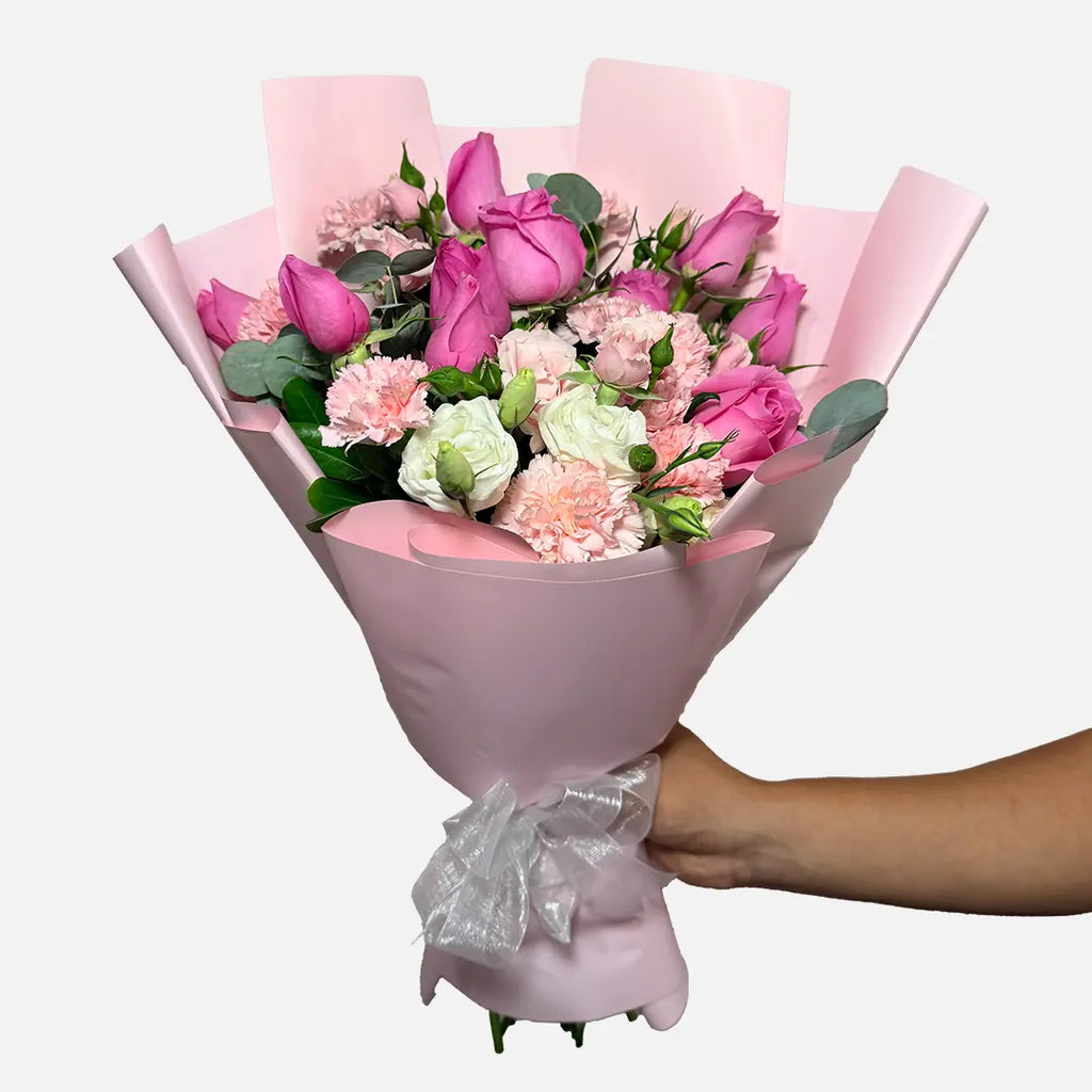 Ramo de 12 rosas rosas, clavel rosa, mini rose rosa y follaje. Envuelto en papel coreano rosa.